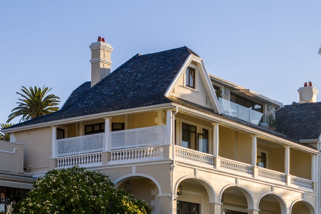 Ellerman House, a cream Edwardian house with white verandas above its terraces, in the evening sun