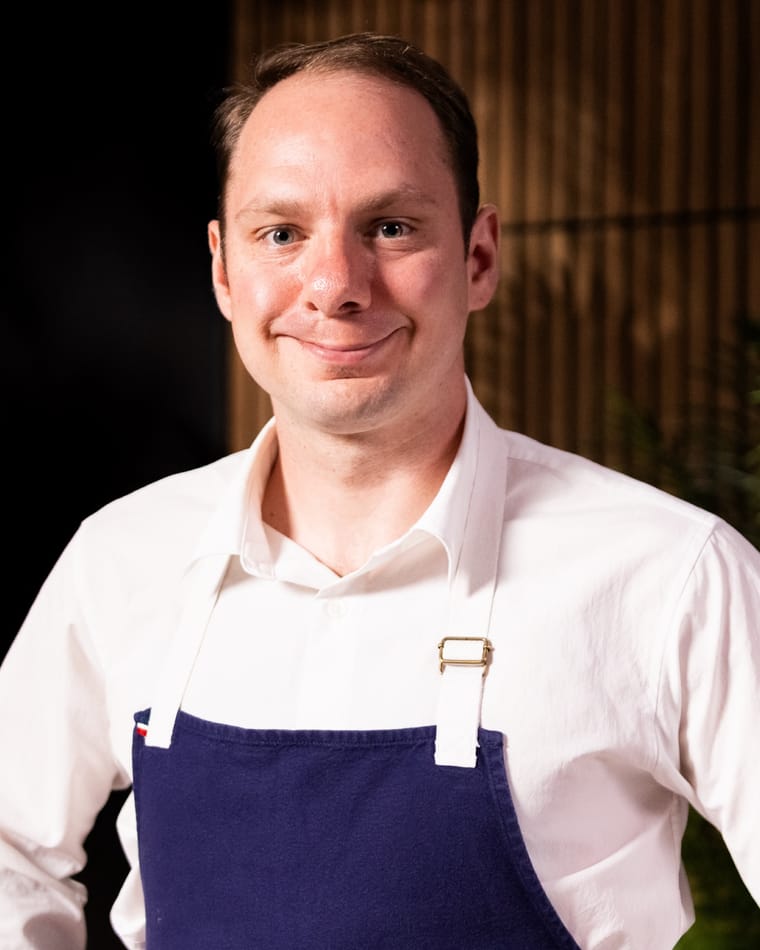Chef Jason McKinney in a white shirt and a navy apron